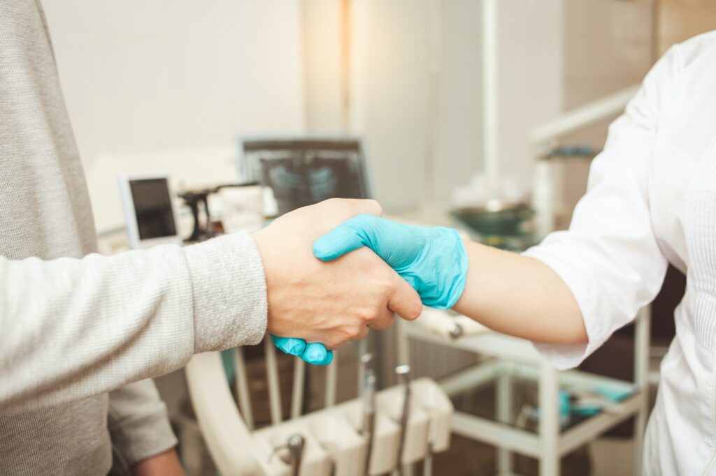 doctor and patient shake hands, happy and satisfied with cooperation, friendly dentist, professional